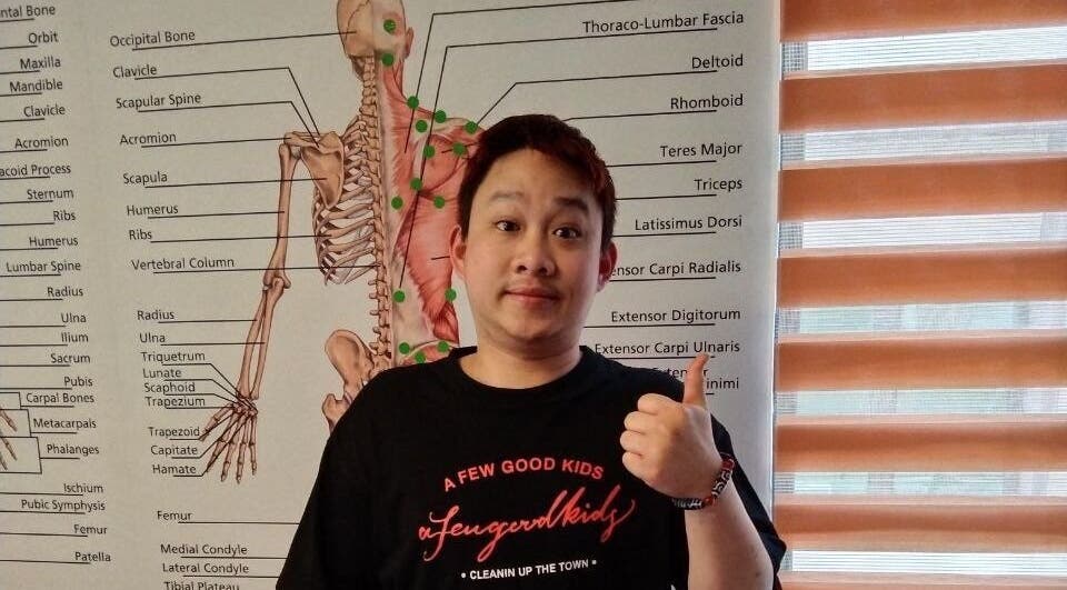 Person giving thumbs up at Advanced Muscle Therapy, Petaling Jaya, Selangor, MY in front of anatomy chart.