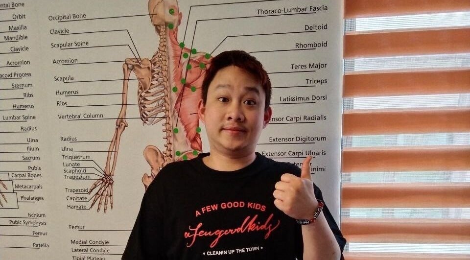 Person giving thumbs up at Advanced Muscle Therapy, Petaling Jaya, Selangor, MY in front of anatomy chart.