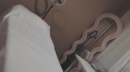 Relaxing treatment room at Contour Me, Aubin Grove, Western Australia, AU with a cozy massage table and mirror.