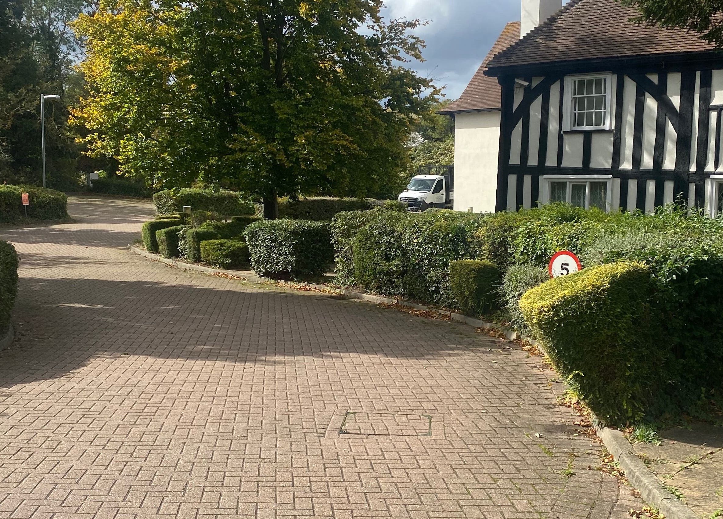 Scenic driveway at Ebbsfleet Aesthetics, Northfleet, England, GB with lush hedges and historic architecture.