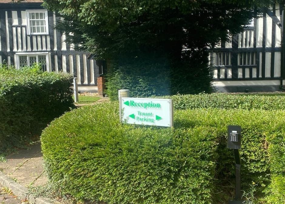 Reception sign amidst lush greenery at Ebbsfleet Aesthetics, Northfleet, England, GB.