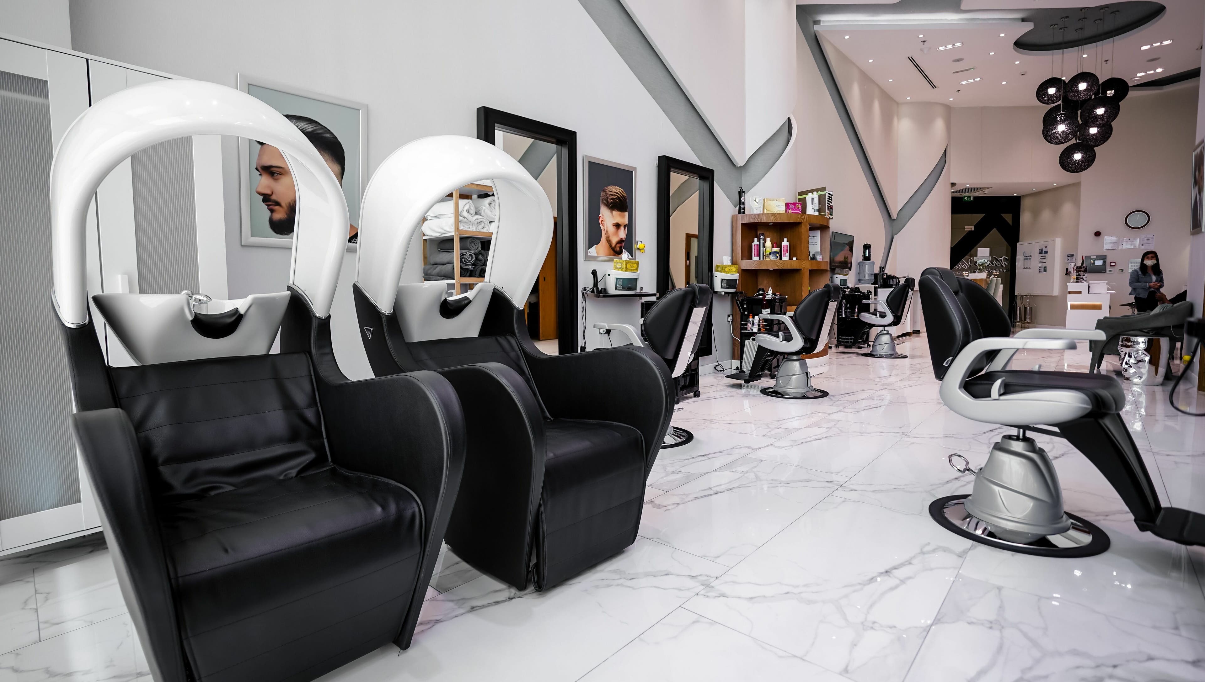 Modern interior of Verona Style Mens Salon in Abu Dhabi, AE, featuring sleek black leather styling chairs.