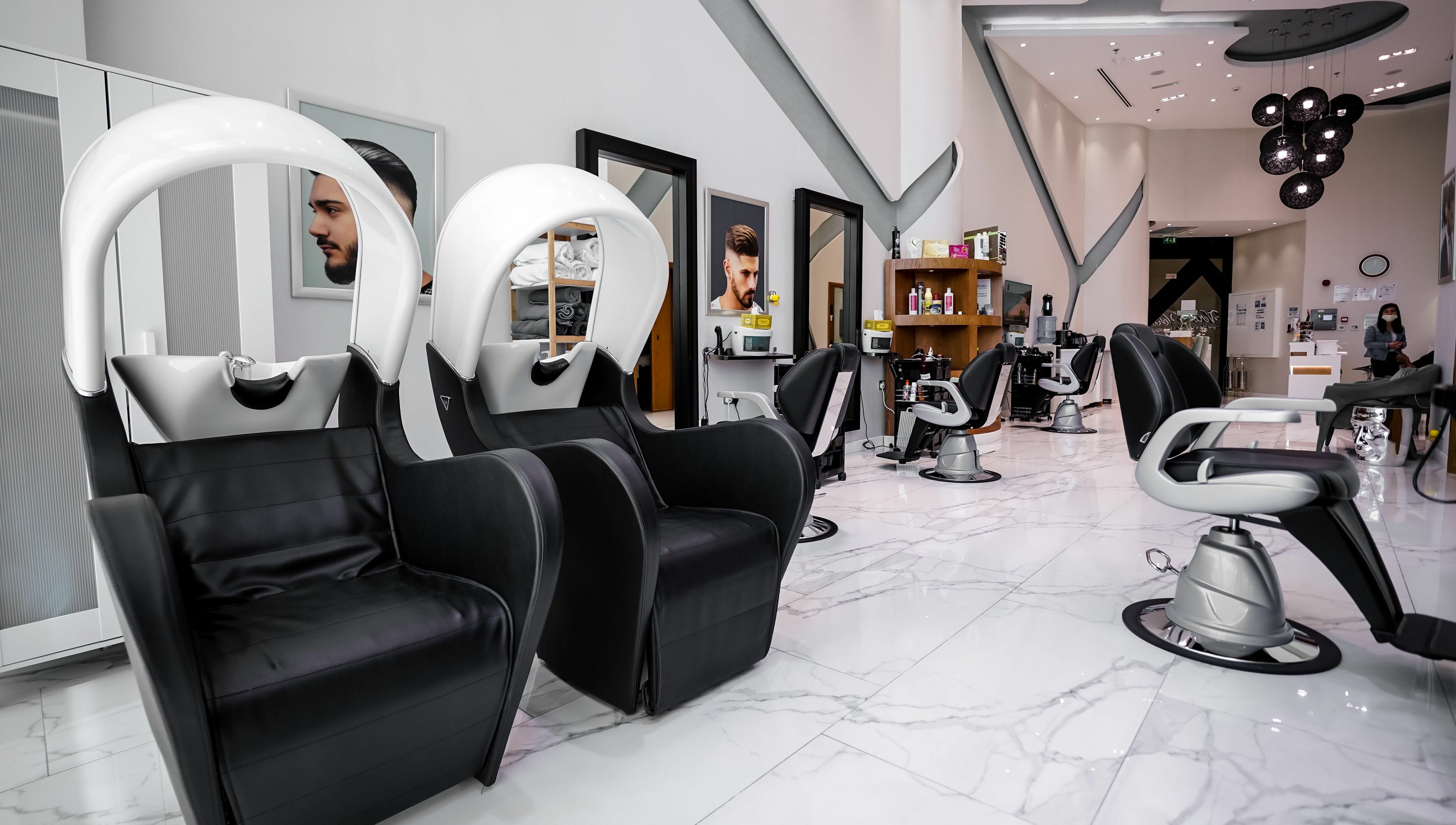 Modern interior of Verona Style Mens Salon in Abu Dhabi, AE, featuring sleek black leather styling chairs.