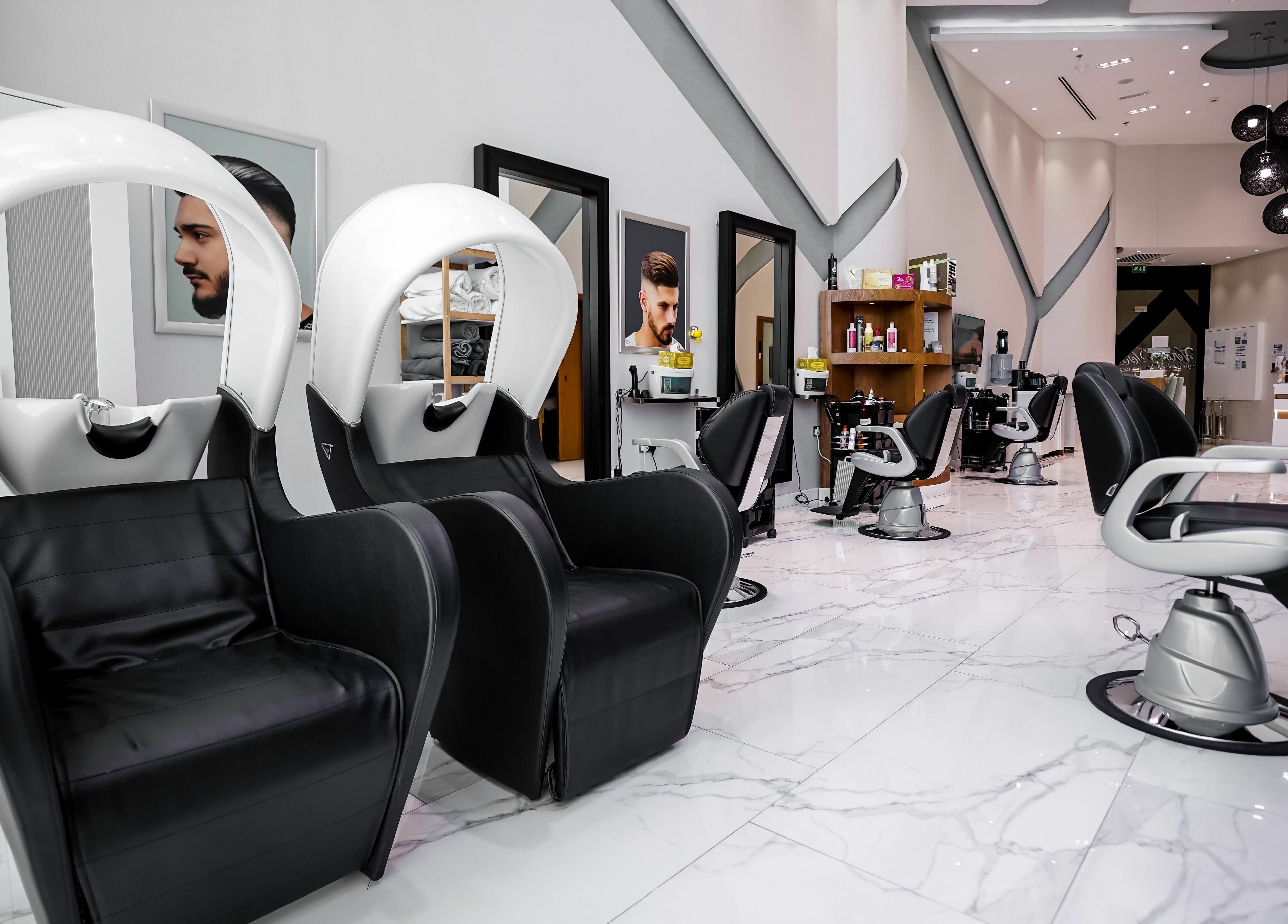 Modern interior of Verona Style Mens Salon in Abu Dhabi, AE, featuring sleek black leather styling chairs.