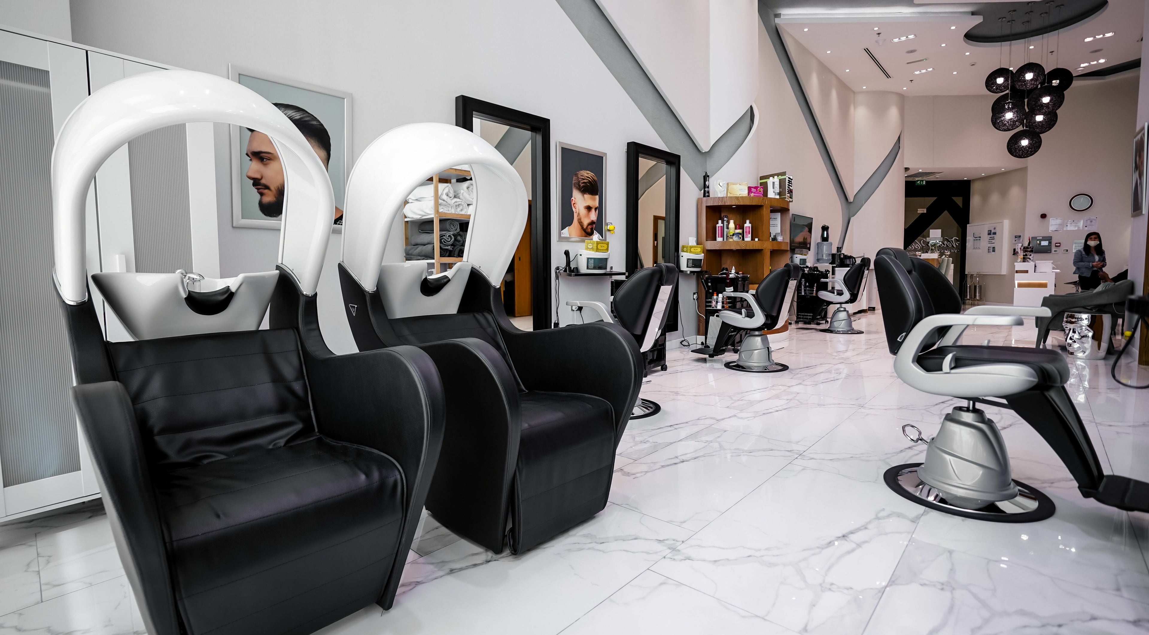 Modern interior of Verona Style Mens Salon in Abu Dhabi, AE, featuring sleek black leather styling chairs.
