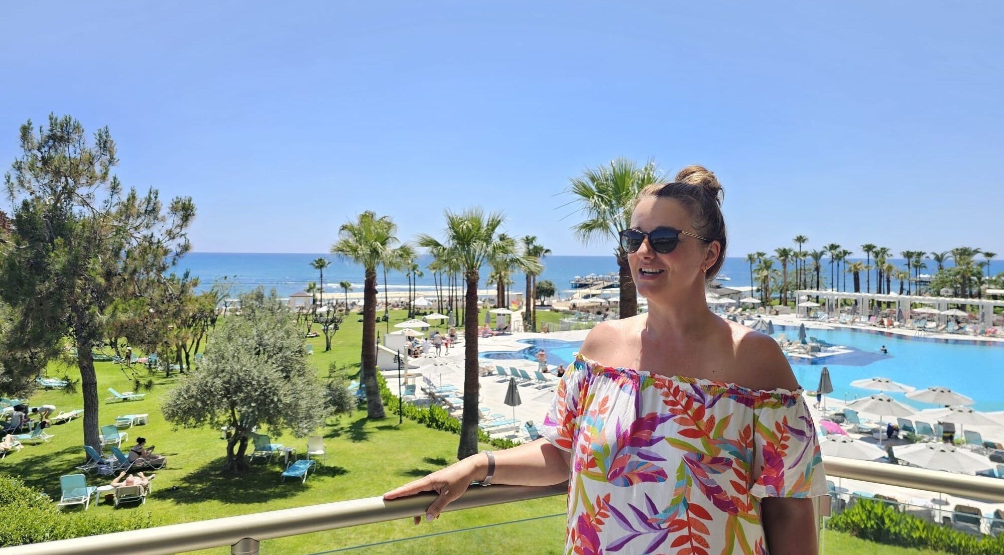 Relaxing poolside view at Iliana’s Hair Salon, Chineham, England, GB, with palm trees and ocean in backdrop.