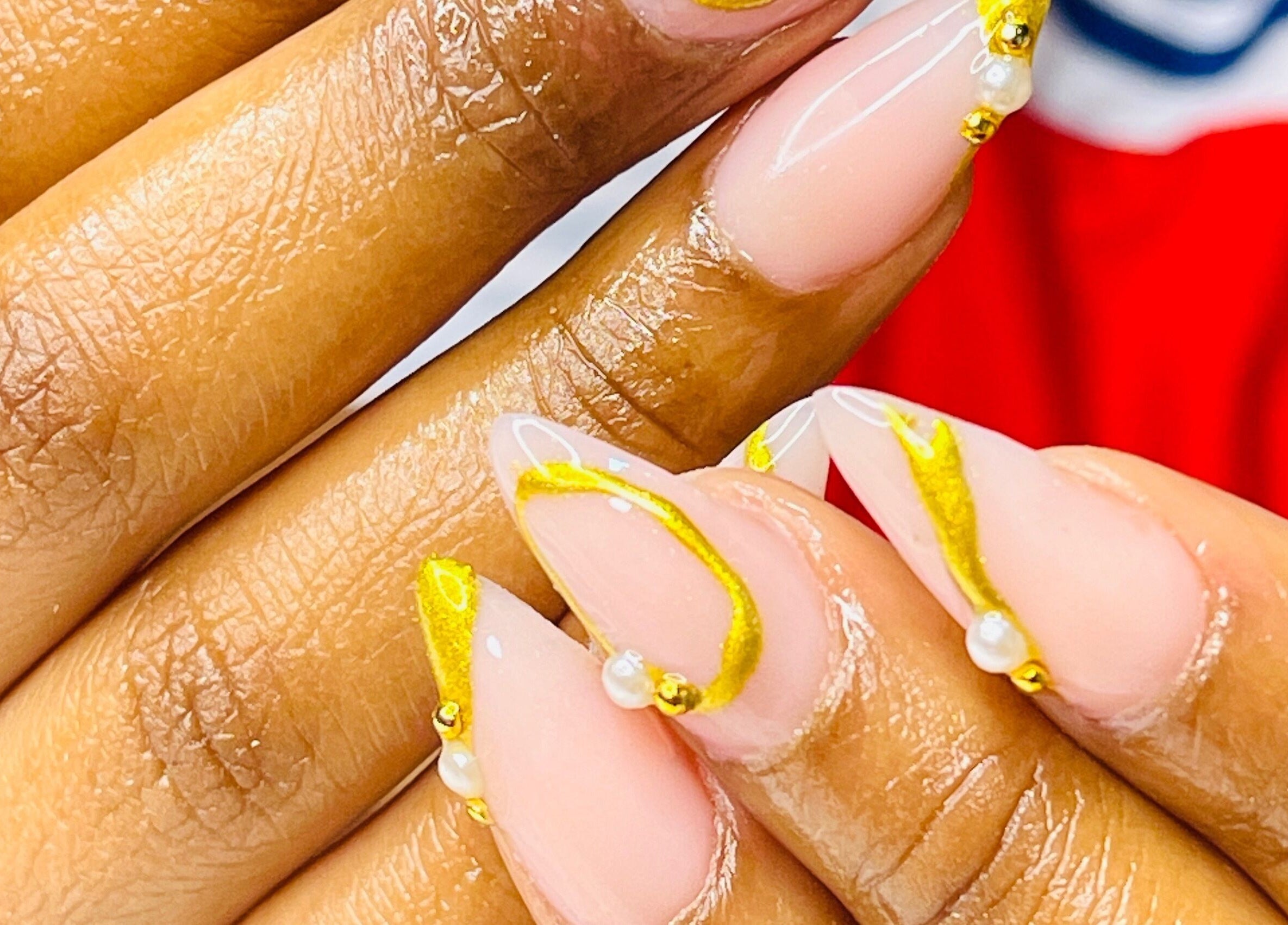 Close-up of intricate gold nail art at African Girls Hair, Roodepoort, Gauteng, ZA.