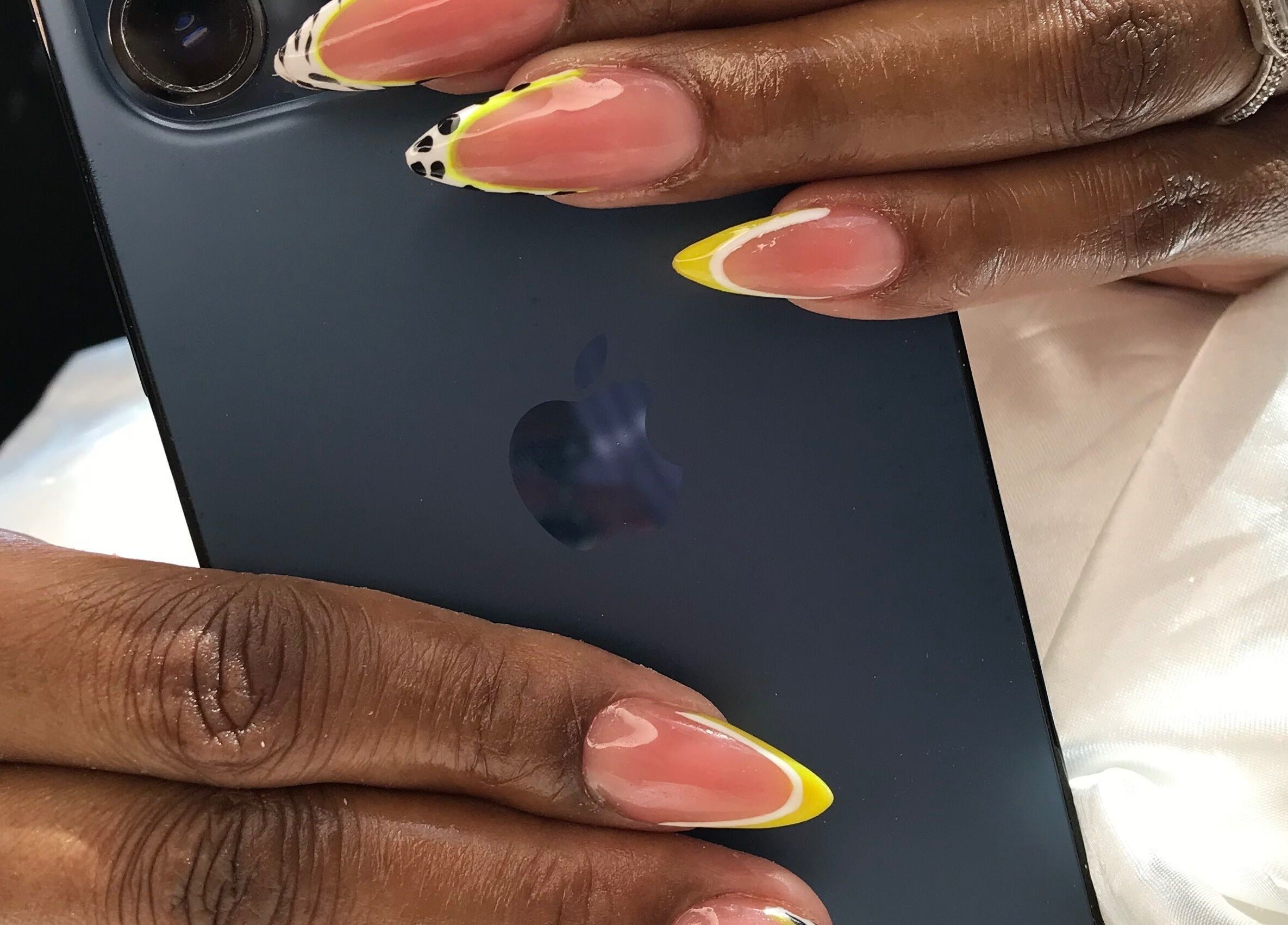 Close-up of vibrant nail art design at African Girls Hair, Roodepoort, Gauteng, ZA, showcasing yellow-tipped nails.