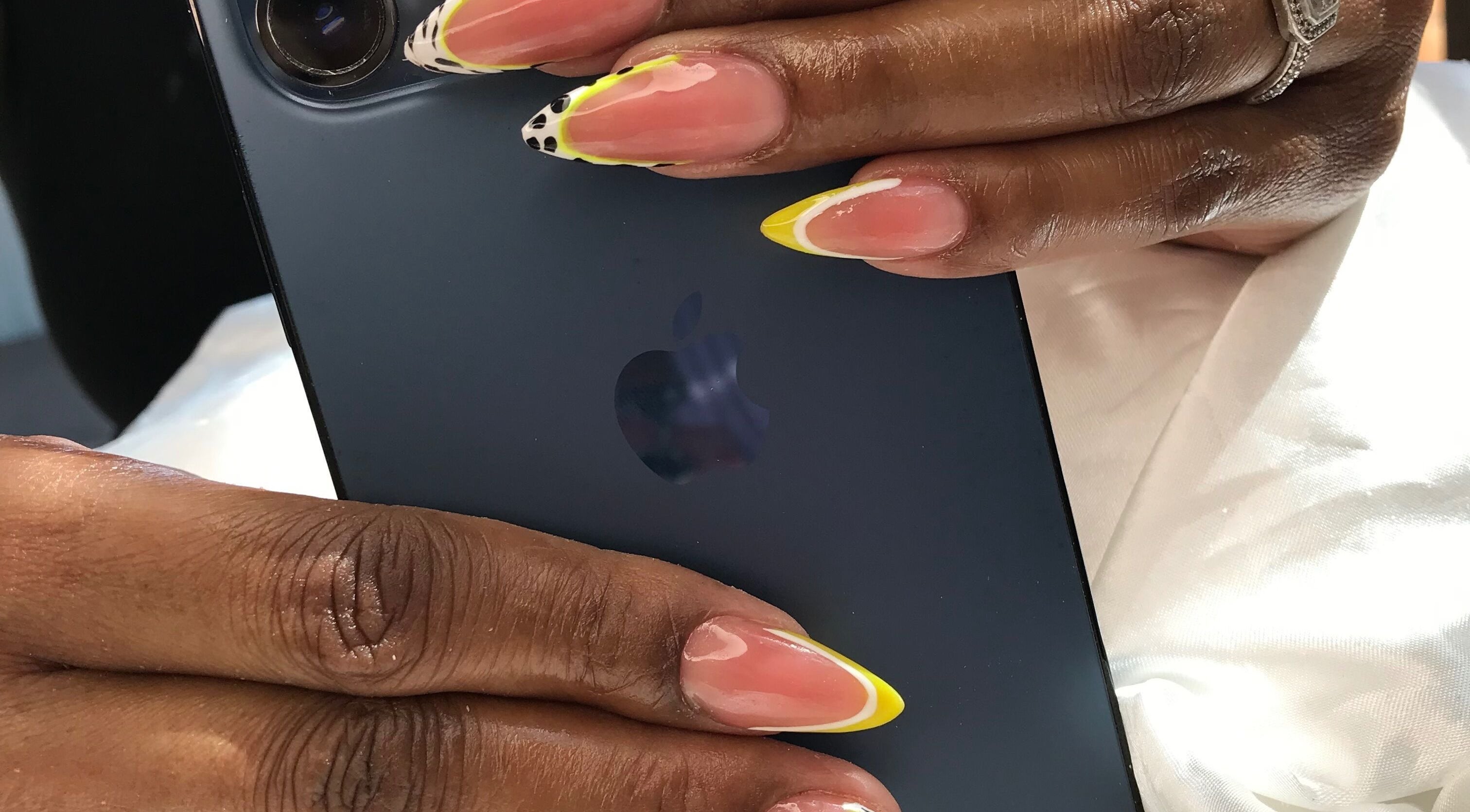 Close-up of vibrant nail art design at African Girls Hair, Roodepoort, Gauteng, ZA, showcasing yellow-tipped nails.