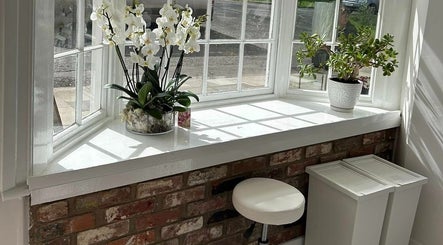 Bright window with orchids at Manes Hair Space, Tenterden, England, GB.