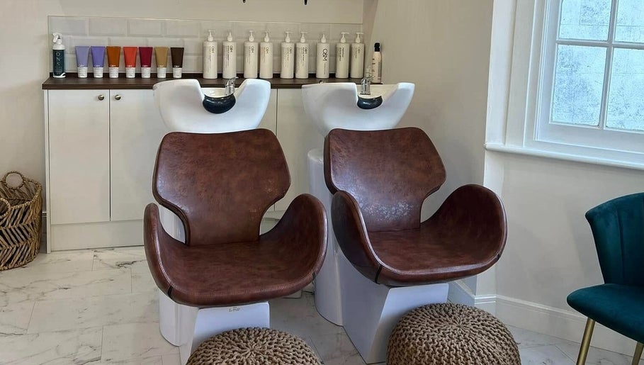 Stylish wash area at Manes Hair Space, Tenterden, England, GB, featuring modern leather chairs and premium hair products.