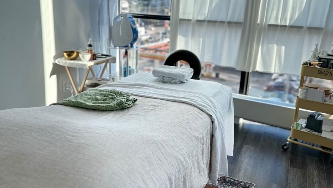 Tranquil massage room at Soo Healing Studio, Toronto, Ontario, CA, with cozy bed and calming decor.
