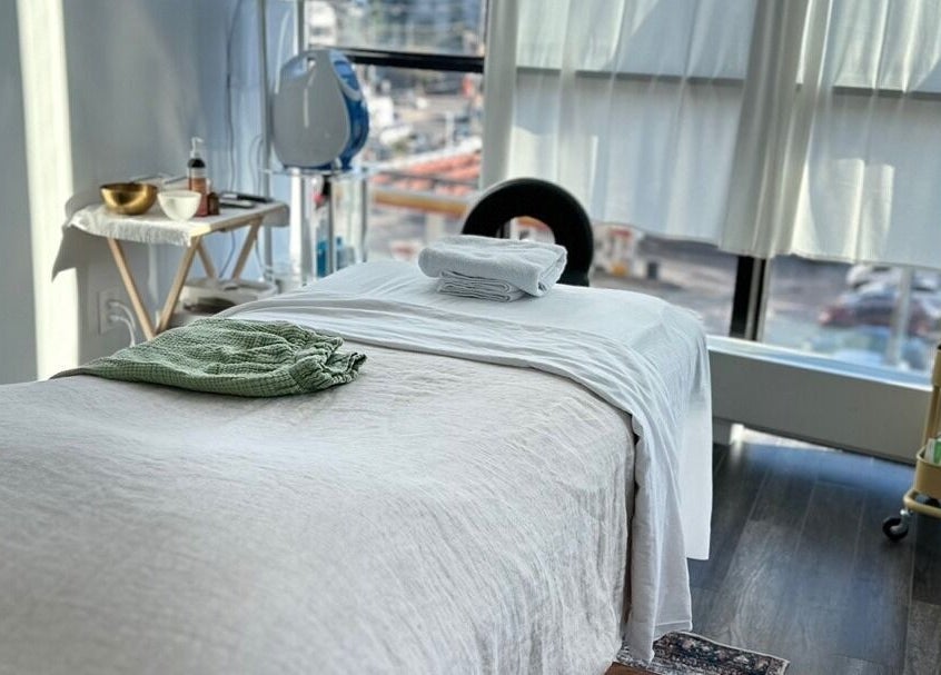 Tranquil massage room at Soo Healing Studio, Toronto, Ontario, CA, with cozy bed and calming decor.