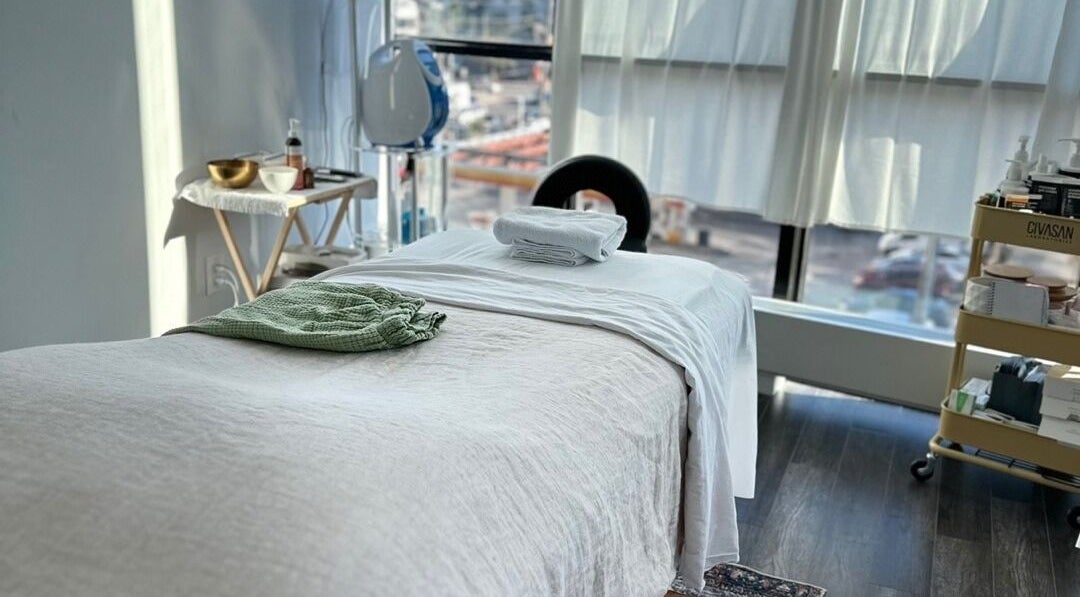 Tranquil massage room at Soo Healing Studio, Toronto, Ontario, CA, with cozy bed and calming decor.
