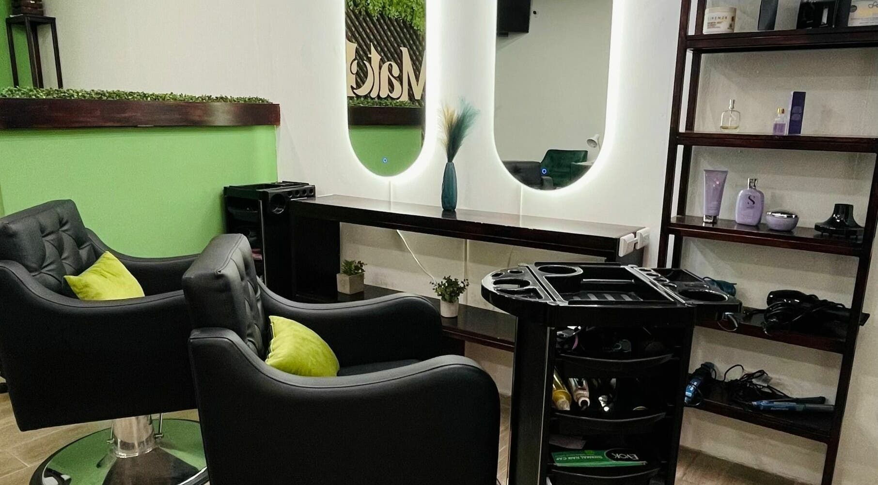 Interior elegante de Match-a Beauty en Ciudad De Guatemala, Guatemala, GT con cómodos sillones y espejo iluminado.