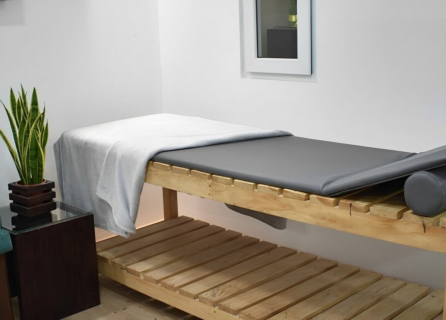 Sala de masajes en Match-a Beauty, Ciudad De Guatemala, Guatemala, GT con mesa y planta decorativa.