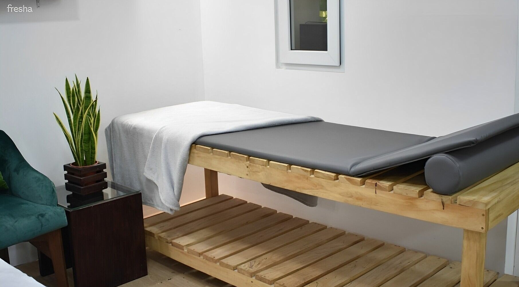 Sala de masajes en Match-a Beauty, Ciudad De Guatemala, Guatemala, GT con mesa y planta decorativa.