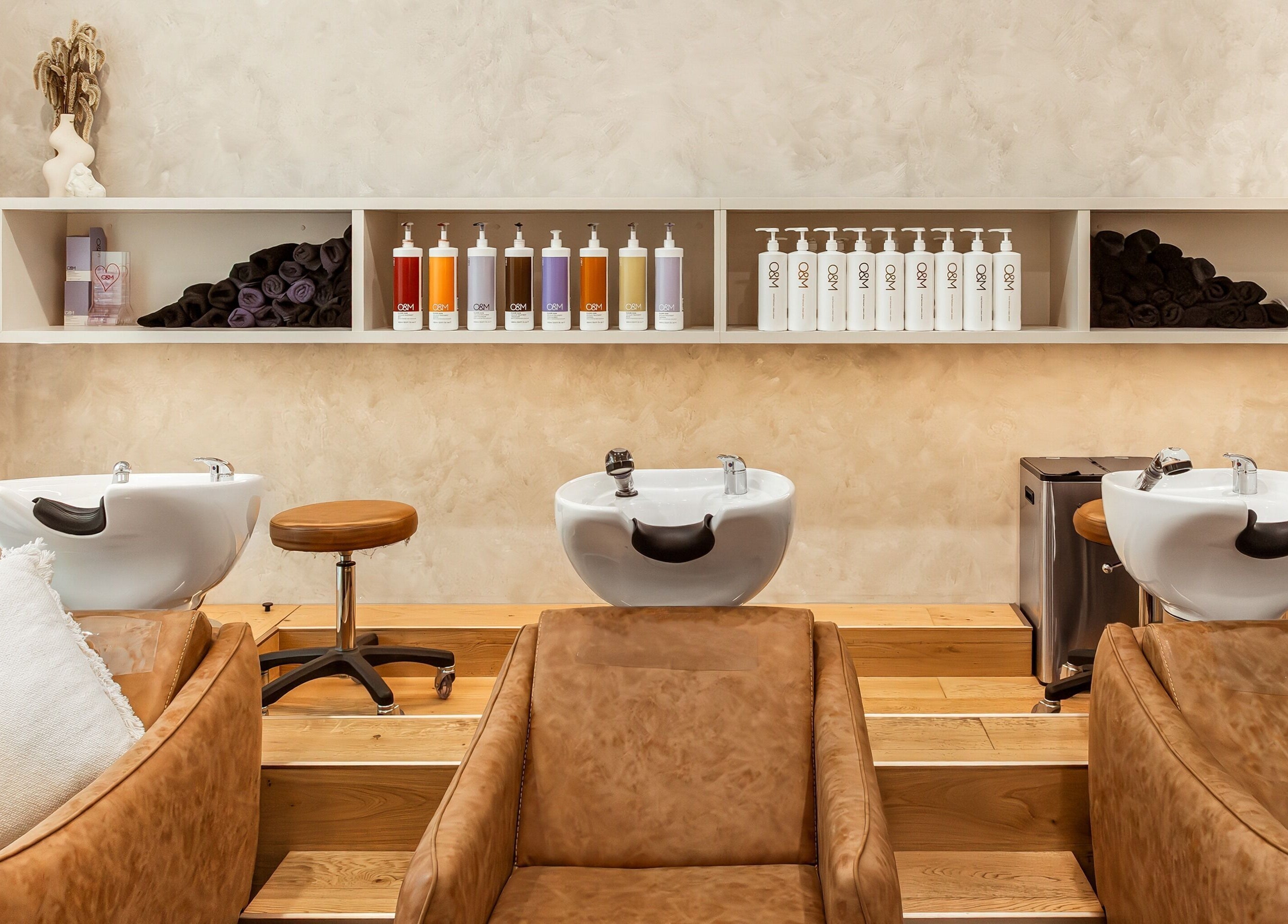 Elegant shampoo area at Lennox Hair, Lennox Head, New South Wales, AU with plush chairs and stylish shelves.