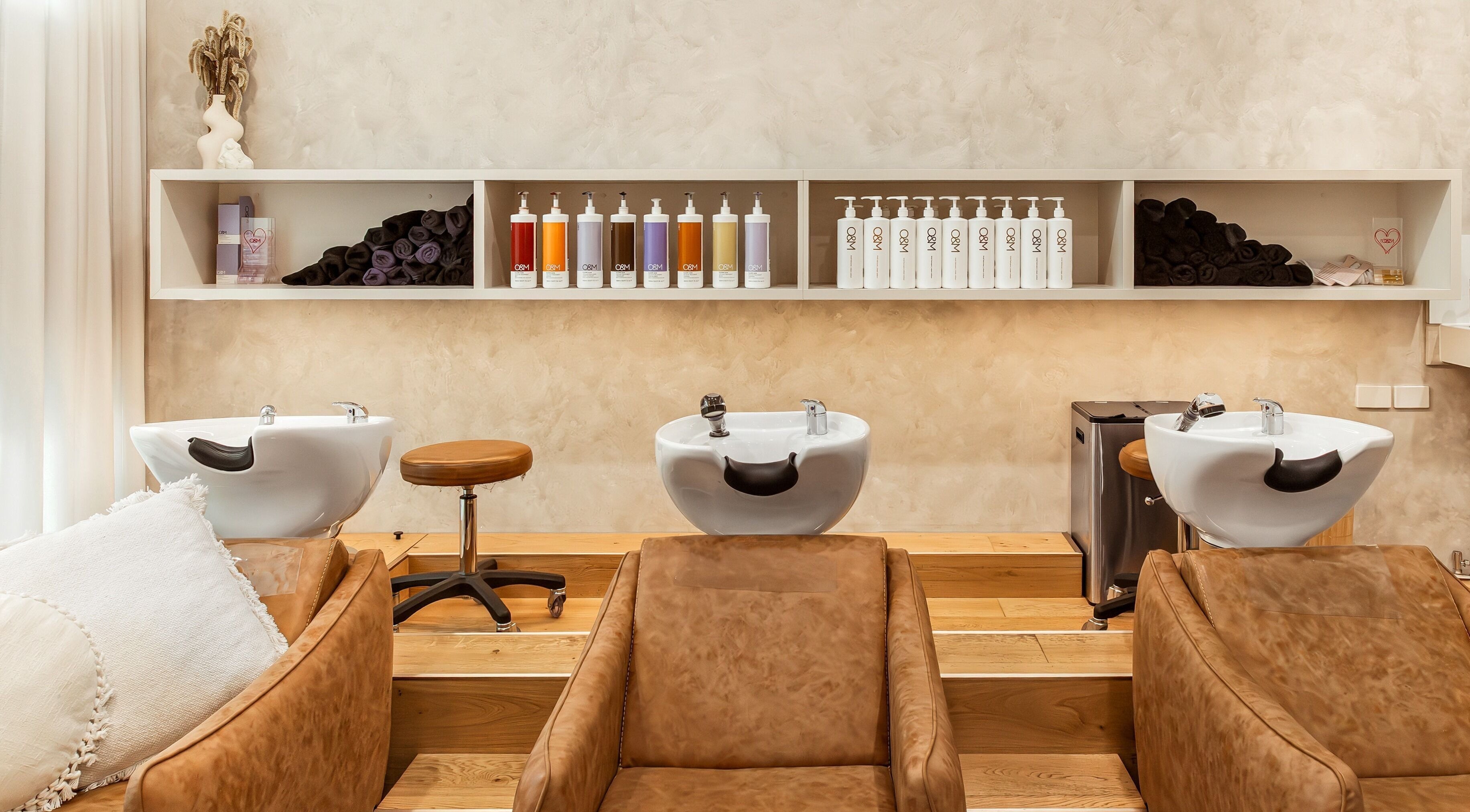Elegant shampoo area at Lennox Hair, Lennox Head, New South Wales, AU with plush chairs and stylish shelves.