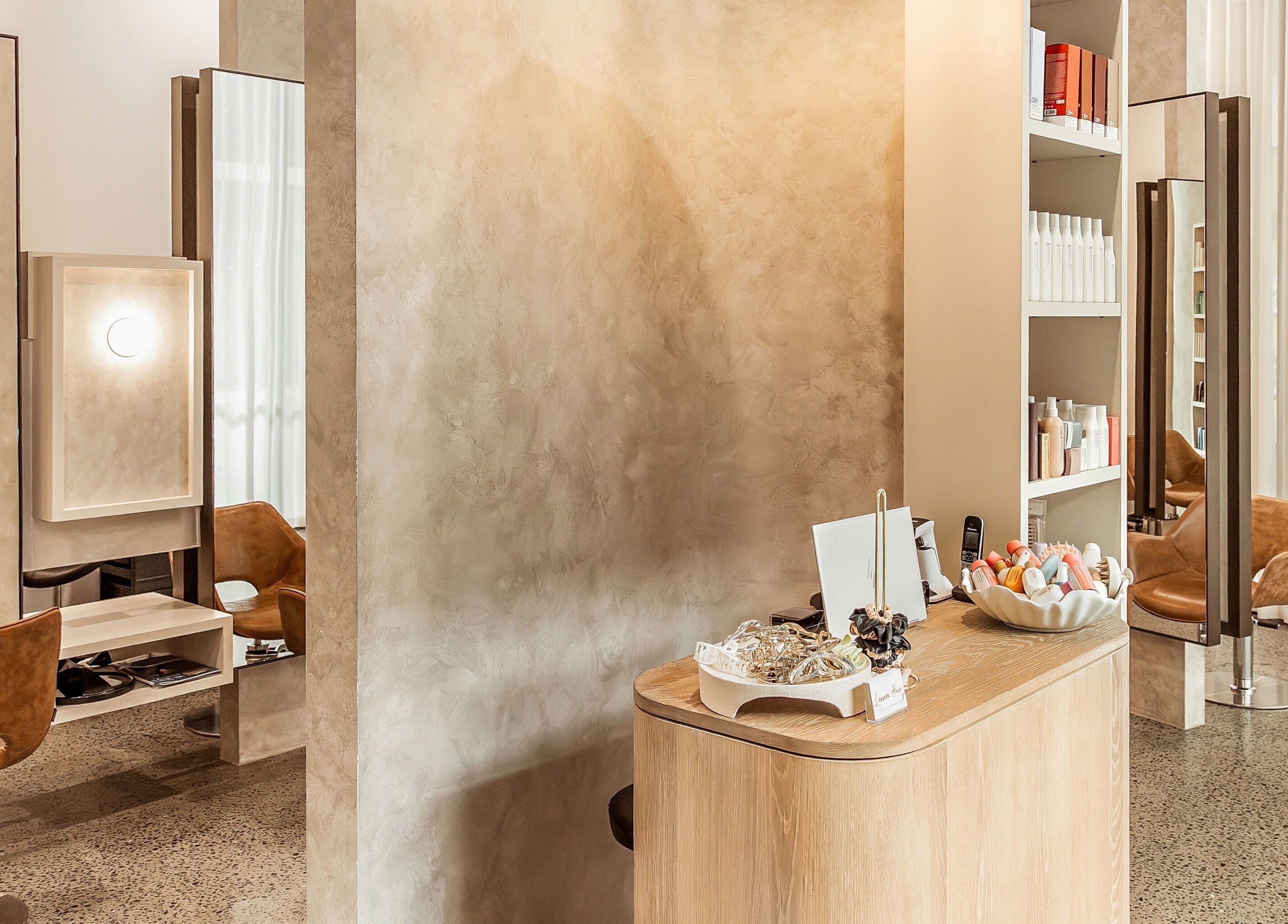 Modern interior of Lennox Hair salon in Lennox Head, New South Wales, AU with stylish chairs and product shelves.