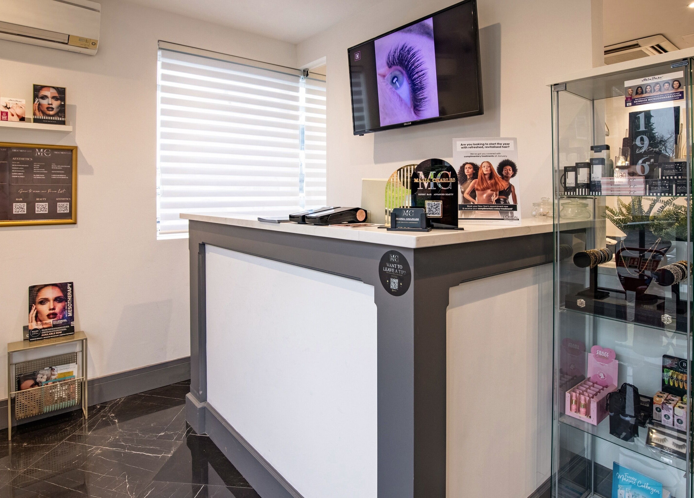 Reception area of Maria Charles Hair Crawley, showcasing a modern desk and product display. Crawley, England, GB.