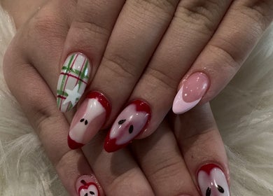 Festive nail art at Bee Sassy Nails in Rocklin, California, US featuring red accents and holiday designs.