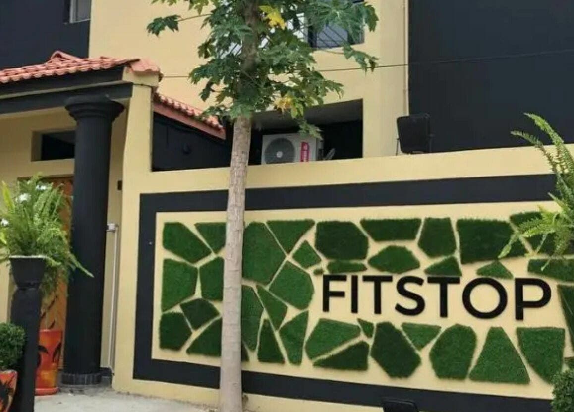 Entrée de Fitstop Sen à Dakar. Design moderne et végétation luxuriante pour détente et bien-être.