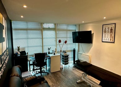 CLINIC 31 - SPORTS MASSAGE THERAPY & HIJAMA CUPPING interior, featuring massage table and anatomical posters, Birmingham, England, GB.