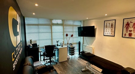 CLINIC 31 - SPORTS MASSAGE THERAPY & HIJAMA CUPPING interior, featuring massage table and anatomical posters, Birmingham, England, GB.