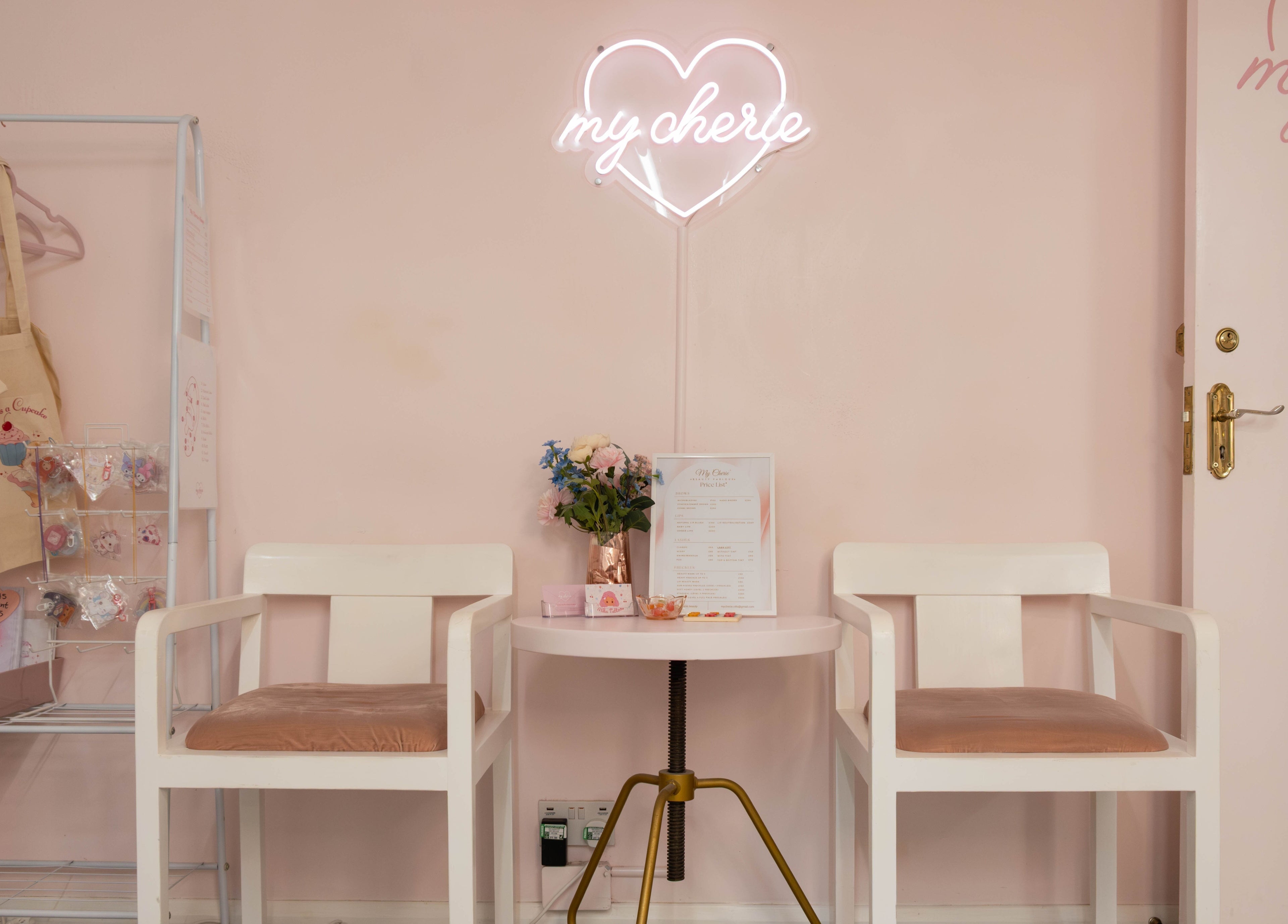 Elegant seating at My Cherie Studio, London, England, GB, with neon sign and flowers.
