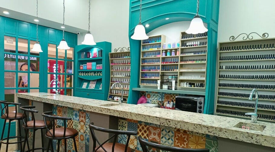 Interior de Coquelicot Nail Salon and Spa en Quito, Pichincha, EC, con elegantes estantes de esmaltes y barra de mármol.