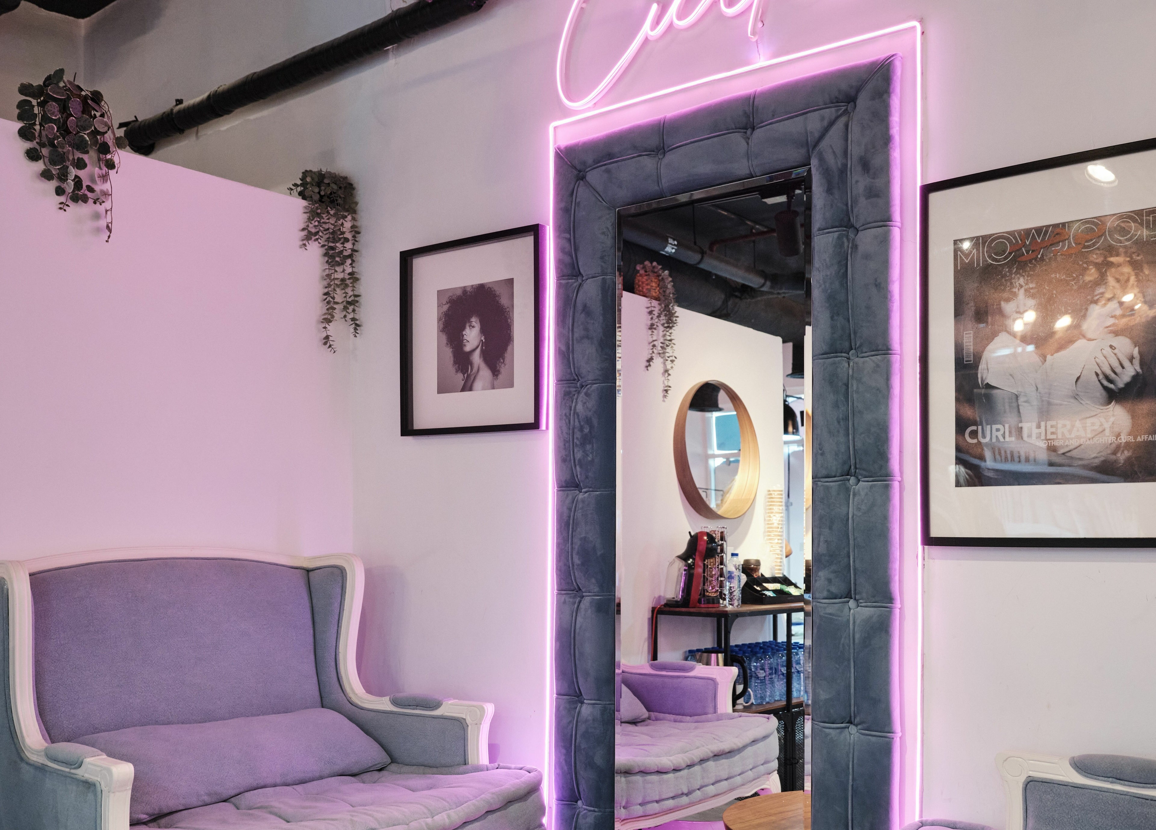 Stylish lounge at The Curl Therapy, Dubai, Dubai, AE, featuring purple seating and neon lighting.