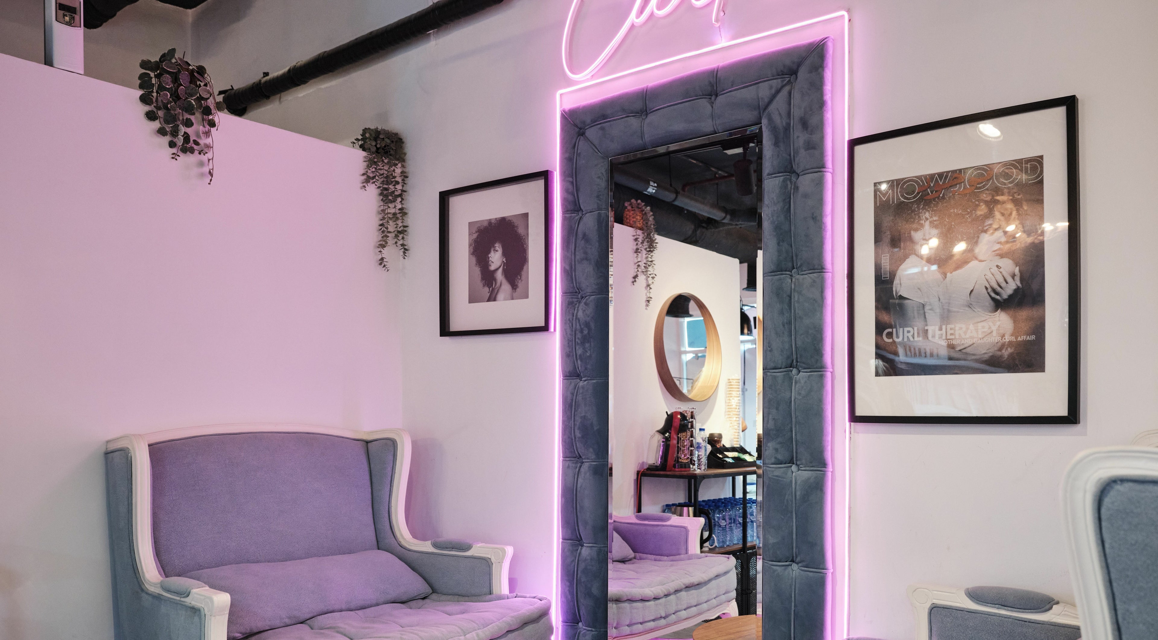 Stylish lounge at The Curl Therapy, Dubai, Dubai, AE, featuring purple seating and neon lighting.