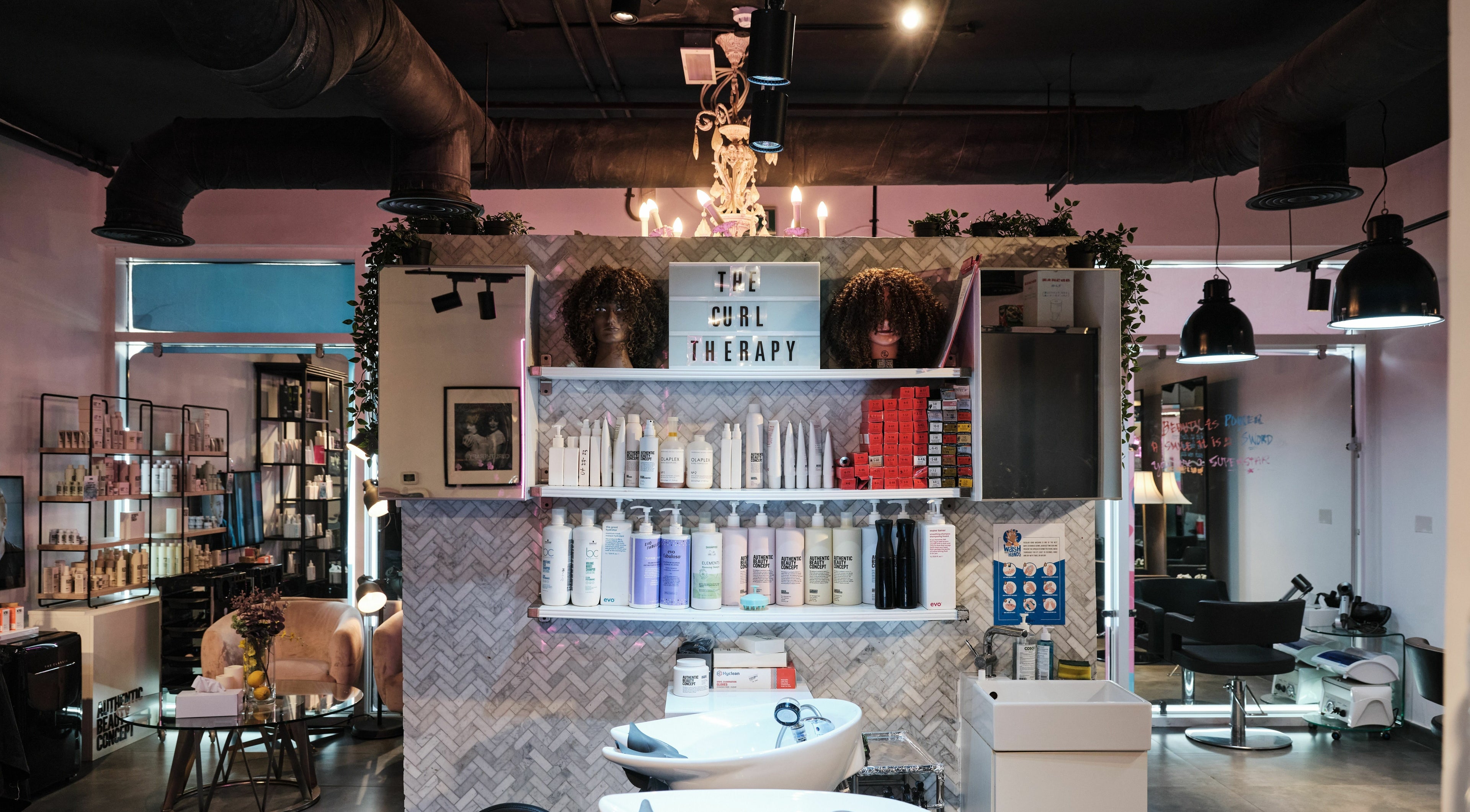 Interior of The Curl Therapy salon in Dubai, Dubai, AE featuring hair products and styling stations.