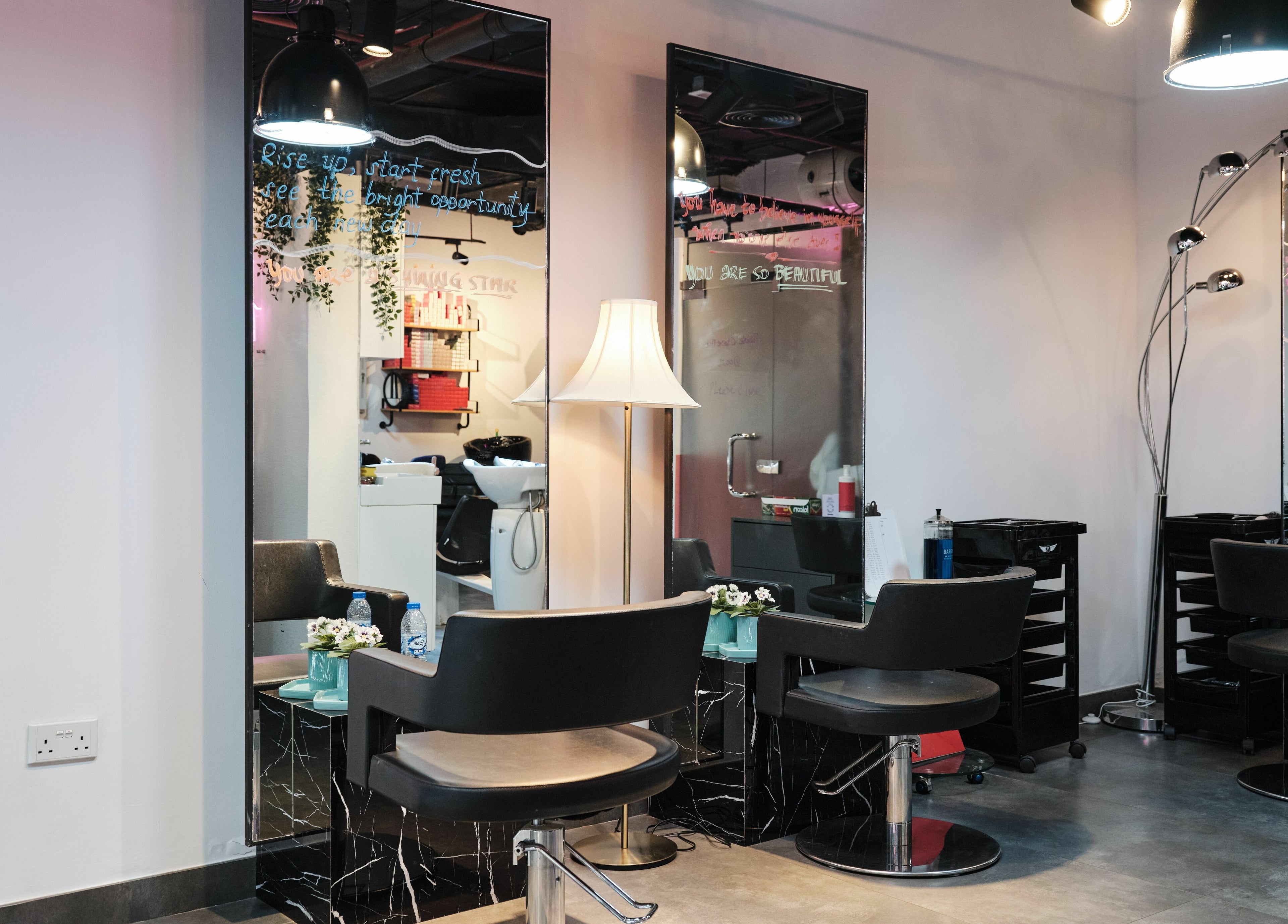 Modern salon chairs and mirrors at The Curl Therapy in Dubai, Dubai, AE, offering a sleek, professional atmosphere.