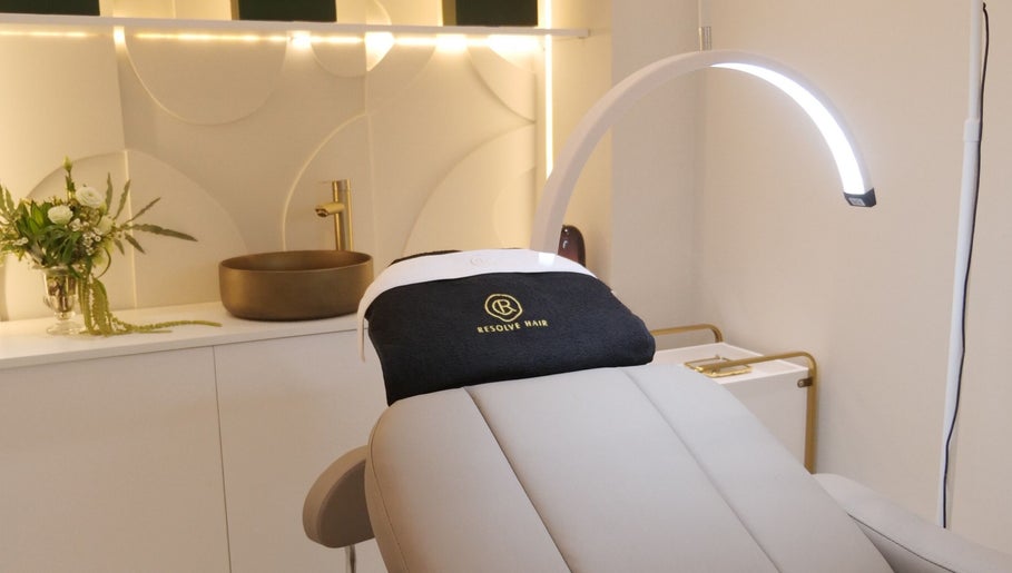 Sala de tratamento luxuosa da Resolve Hair, Dubai, Dubai, AE, com design moderno e vaso de flores.