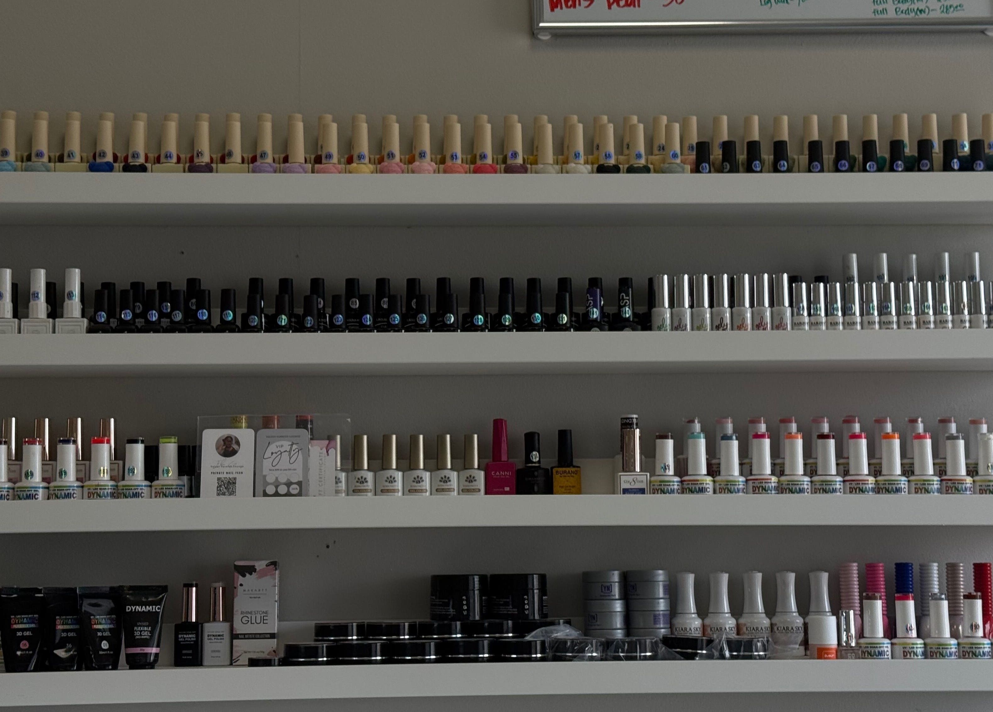 Nail polish shelves at Velvet Varnish Lounge in Spring, Texas, US showcasing a variety of vibrant colors.