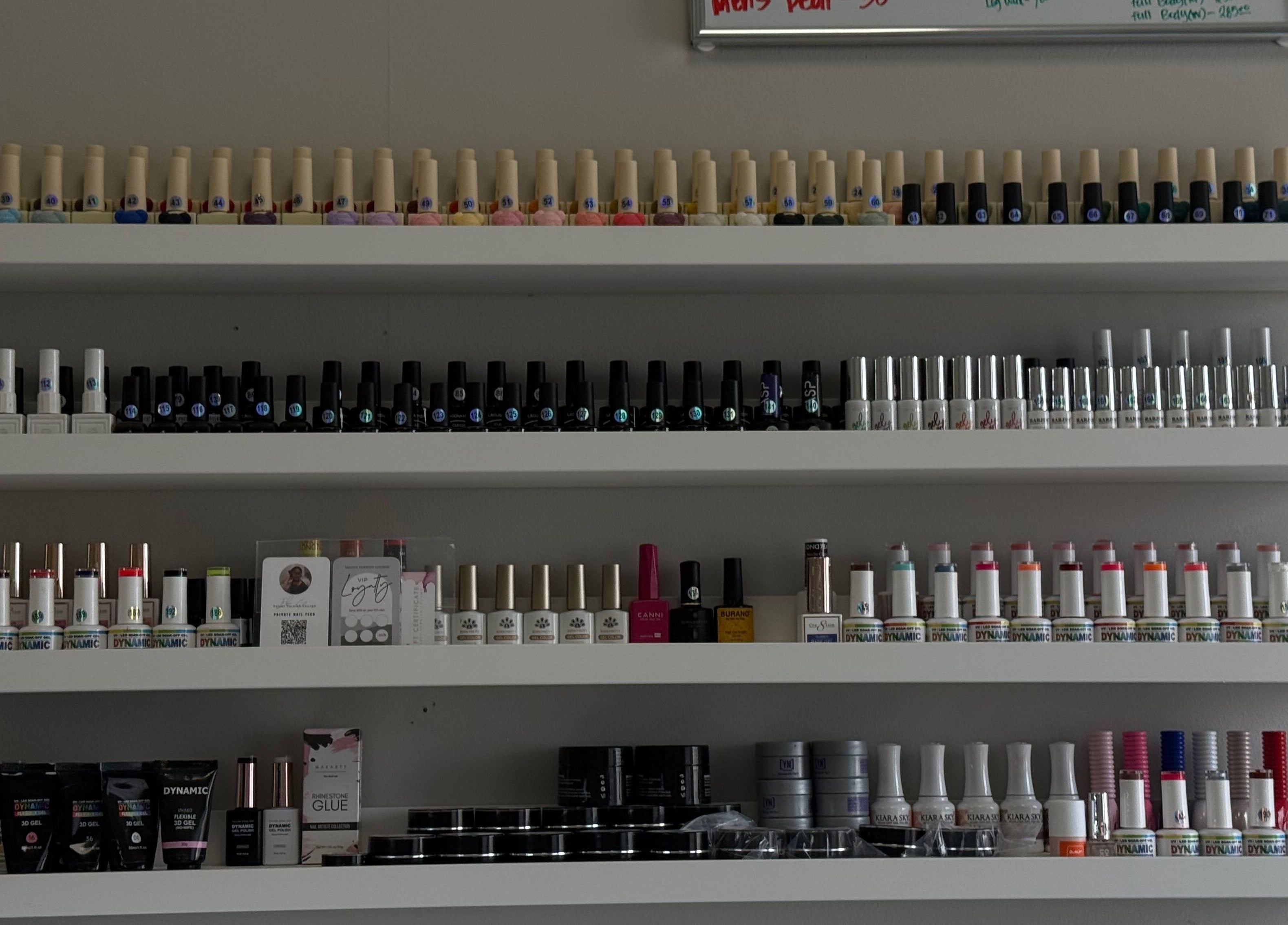 Nail polish shelves at Velvet Varnish Lounge in Spring, Texas, US showcasing a variety of vibrant colors.