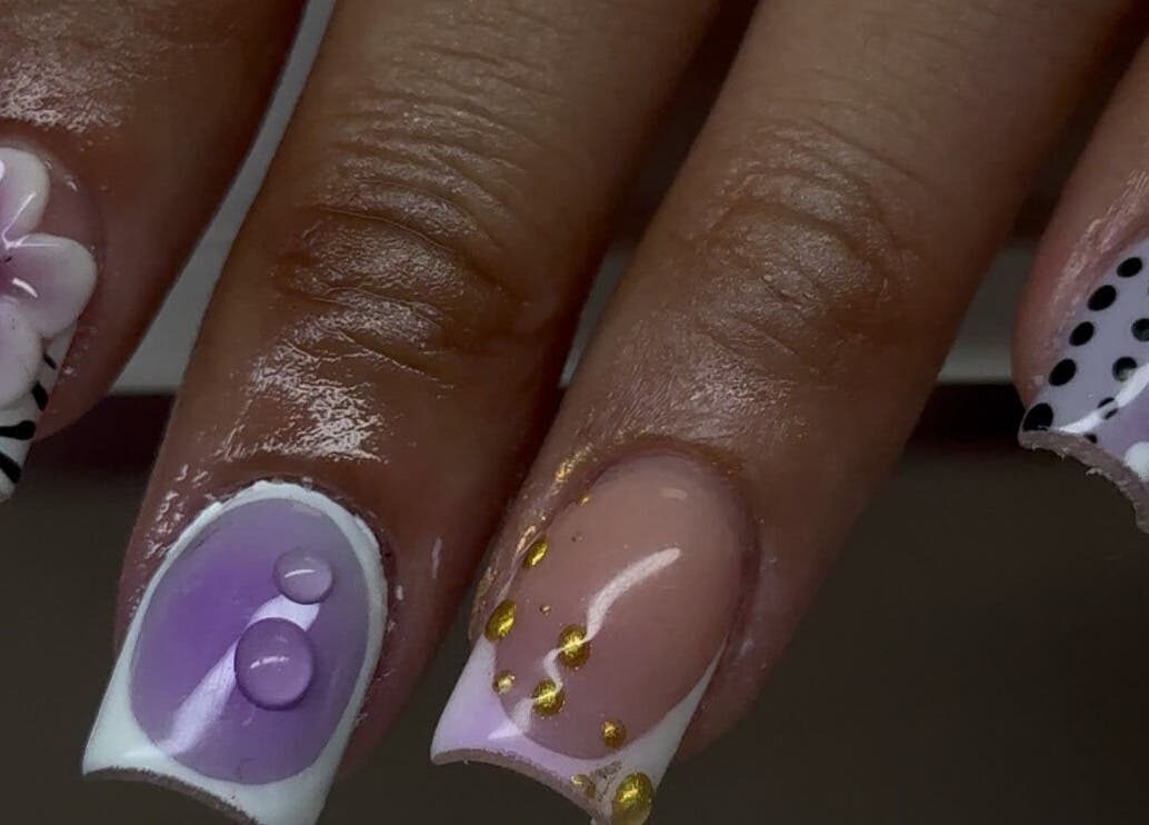 Nail art with purple hues and floral design at Velvet Varnish Lounge, Spring, Texas, US.