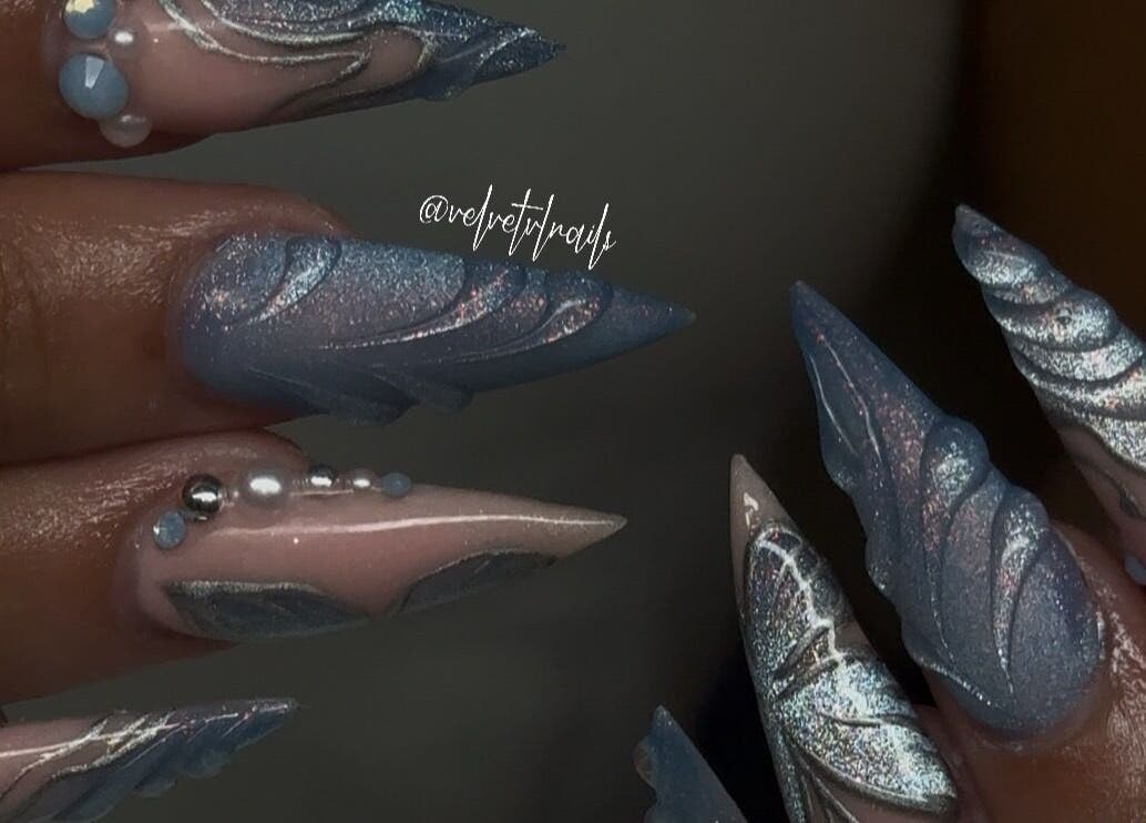 Elegant blue and silver nail art at Velvet Varnish Lounge, Spring, Texas, US, showcases intricate detailing.