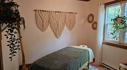 Salle de massage relaxante chez Massothérapie Mainsagère, Val-David, Québec, CA, avec décorations murales.