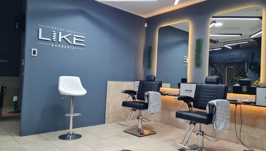 Interior moderno de Like Barbería en San Juan, AR con sillas de barbero y decoración estilizada.