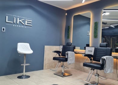 Interior moderno de Like Barbería en San Juan, AR con sillas de barbero y decoración estilizada.