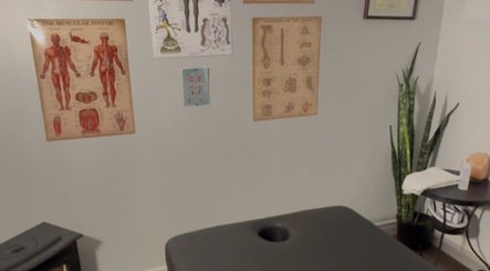 Massage room at Jaiye Health Centre - Ajax Thai Massage in Ajax, Ontario, CA with anatomical posters and a massage table.