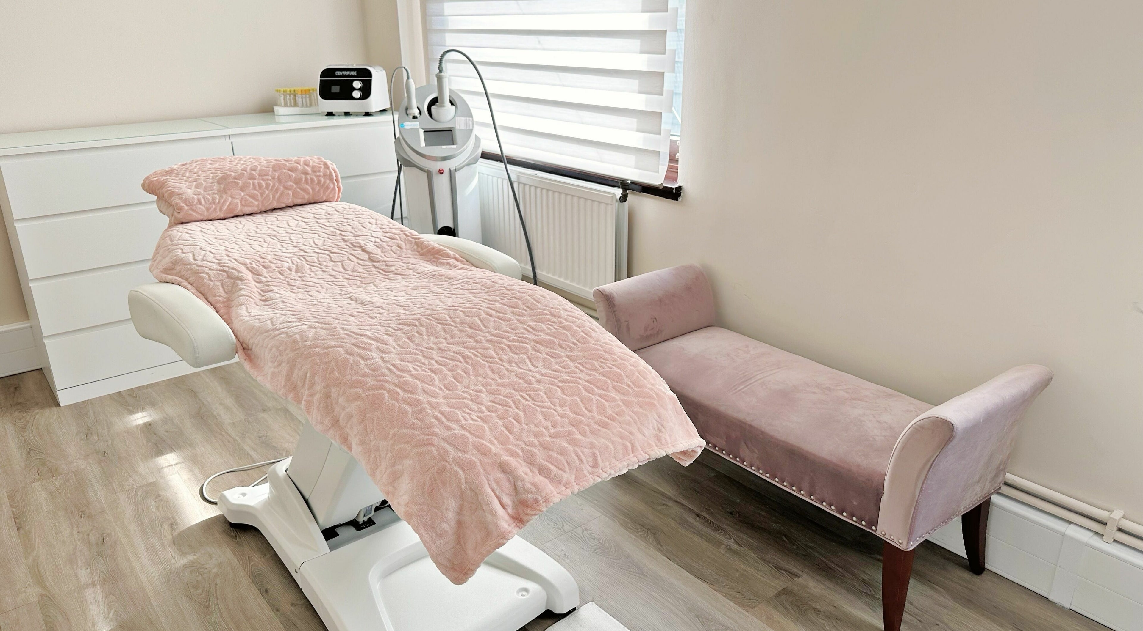 Elegant treatment room at Dr Krasa Beauty&Aesthetic Academy, London, England, GB with plush pink bedding.