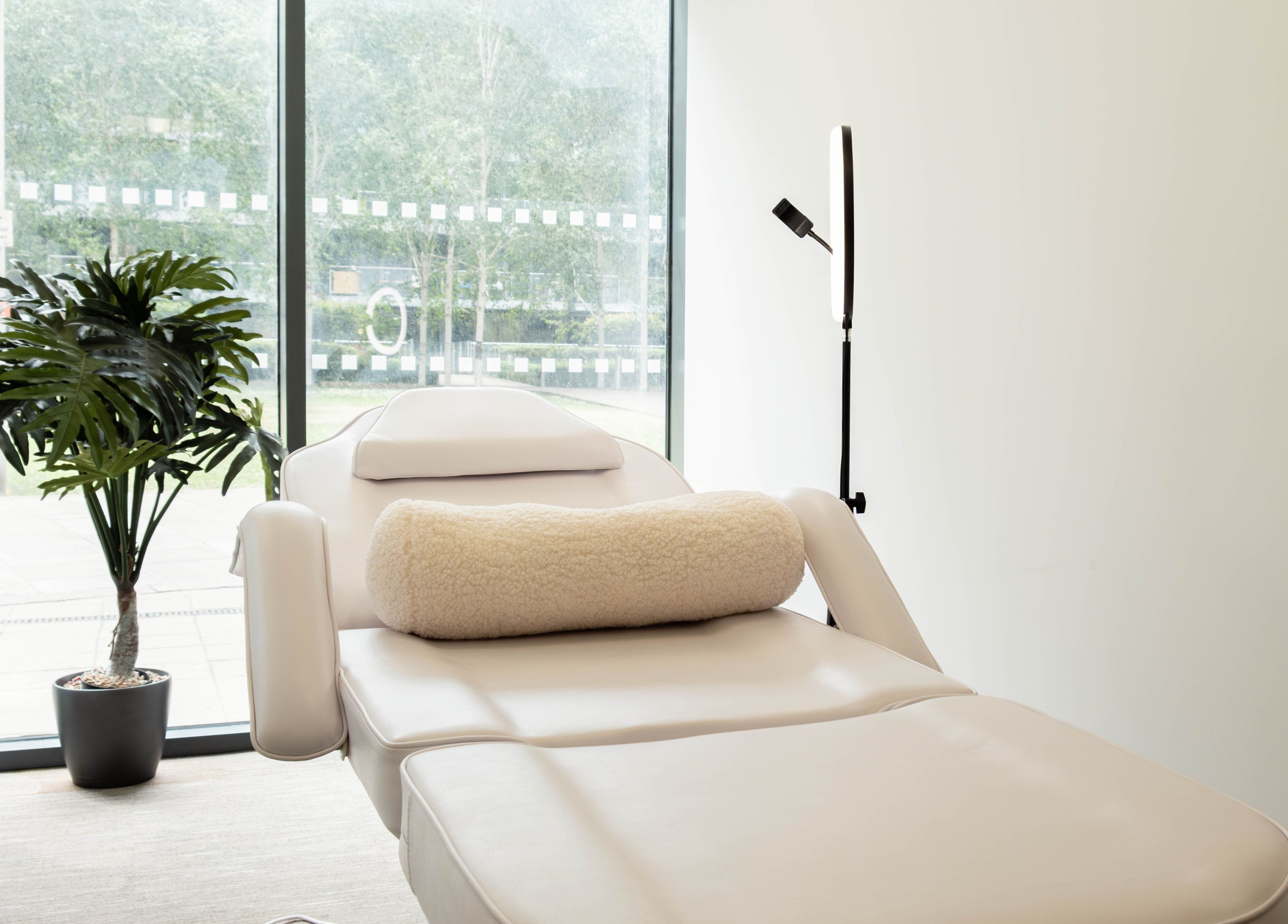 Relaxing treatment room at Fazara Aesthetics in London E14 9DQ, featuring a plush chair and natural light.