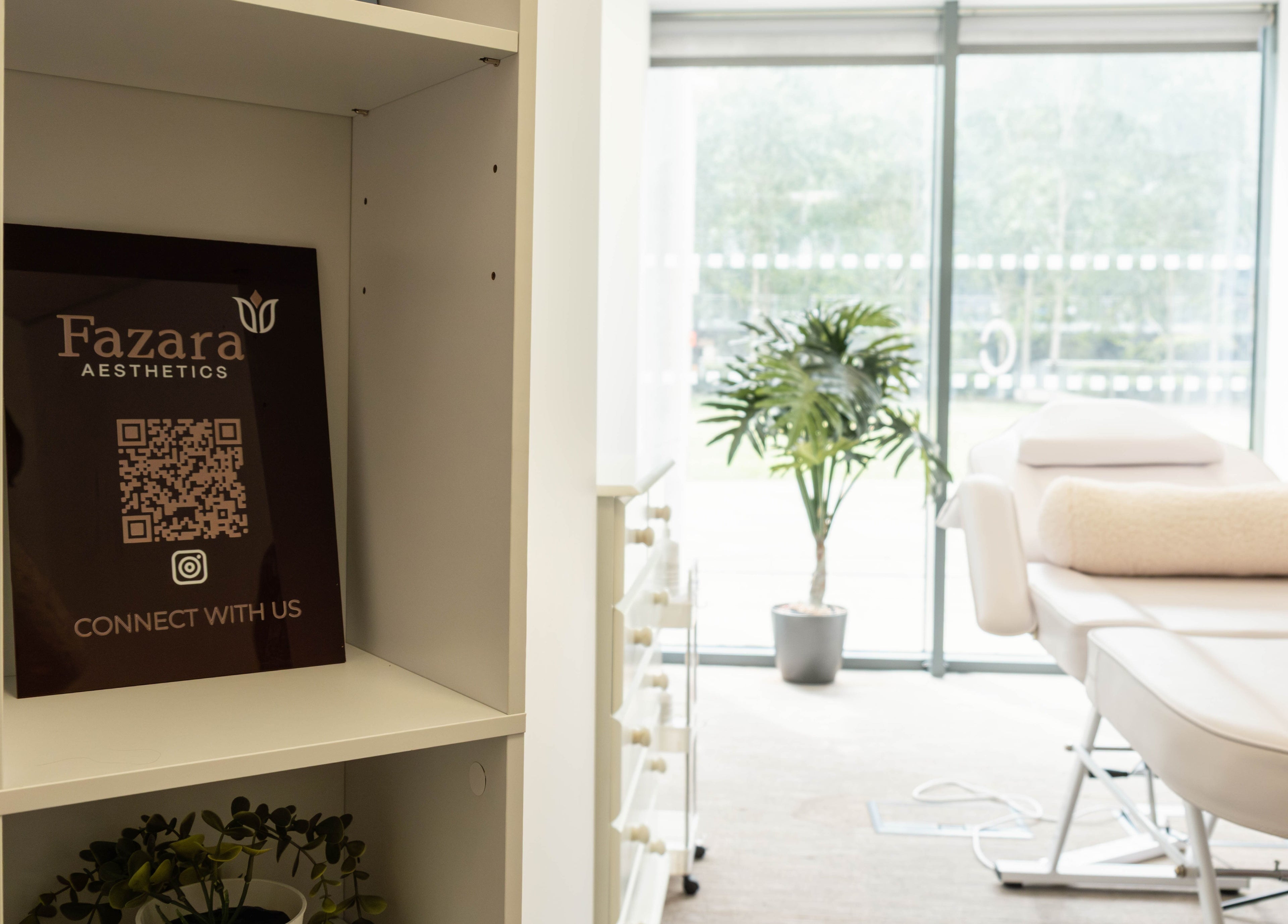 Relaxing treatment room at Fazara Aesthetics, London E14 9DQ, England, with comfortable bed and greenery.