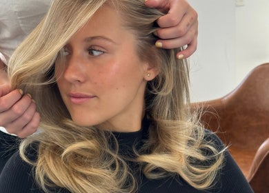 Hair stylist perfecting a blonde hairstyle at Blondelle Club, Albury, New South Wales, AU.