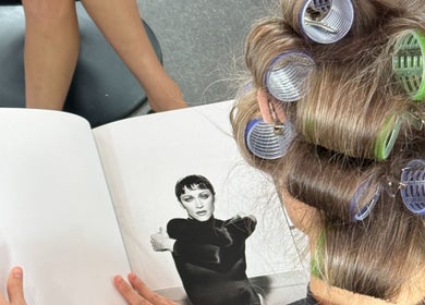 Person at Blondelle Club with curlers in hair, reading a magazine. Albury, New South Wales, AU.
