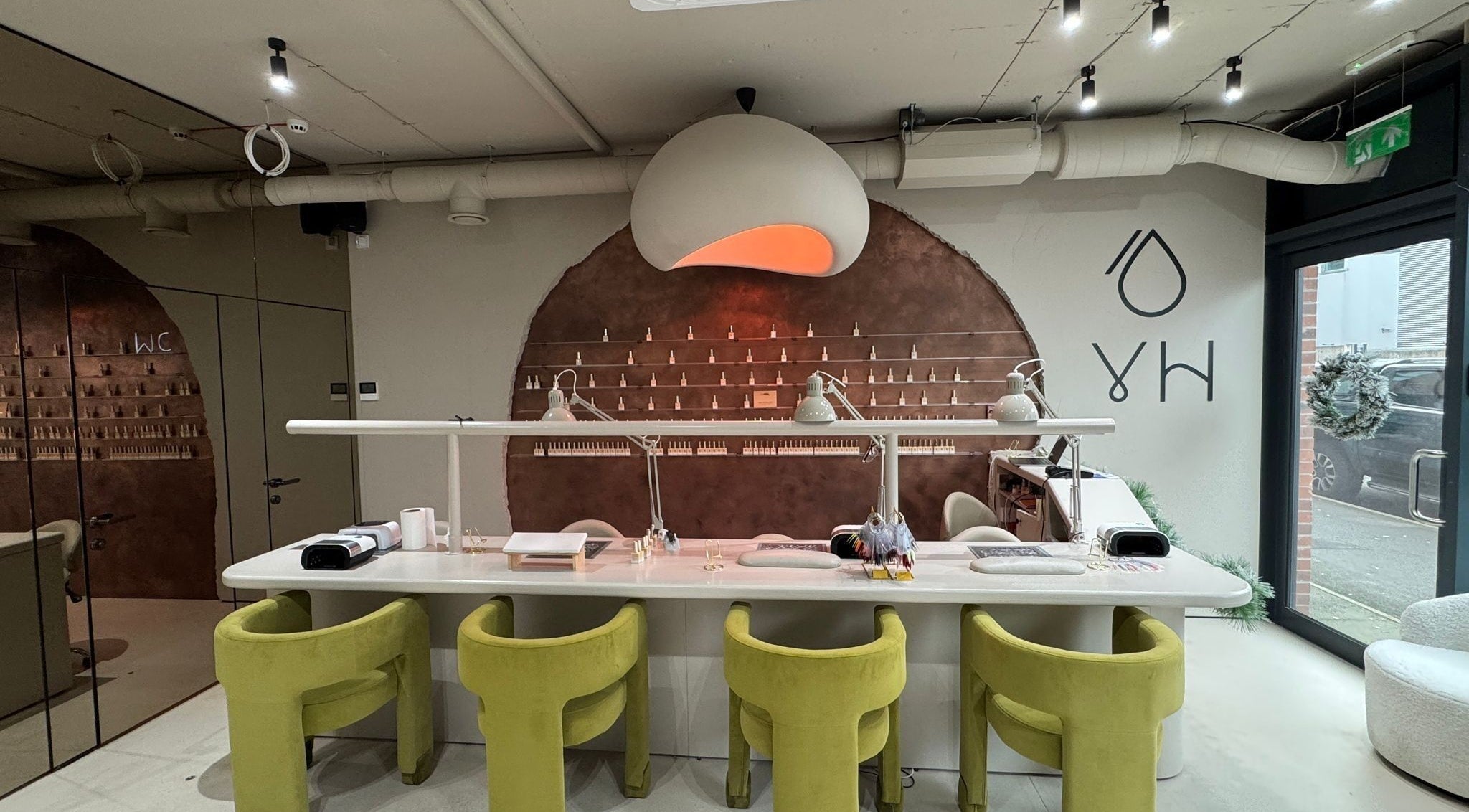 Yulia Hamilton nails & beauty in Manchester, England, GB features a stylish, modern nail bar with green chairs.